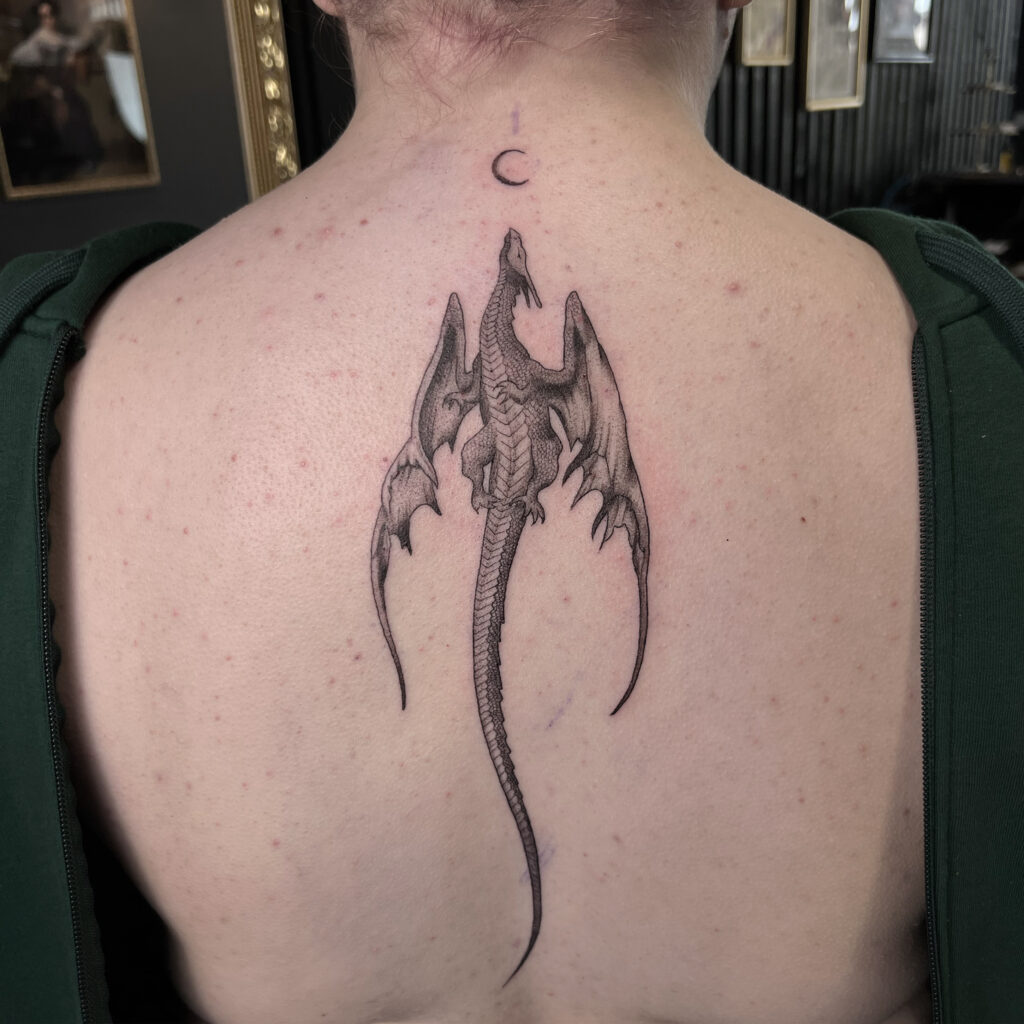 Fineline Tattoo Drache Fineline Tattoo eines Drachens auf dem Rücken, der nach oben fliegt.